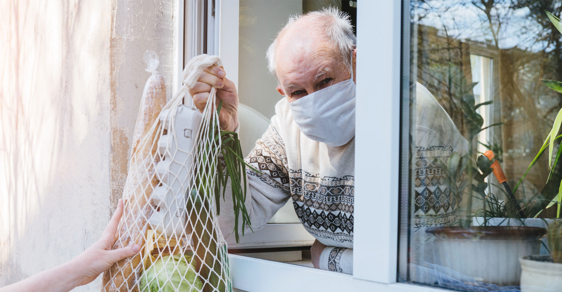 man receiving groceries through the window