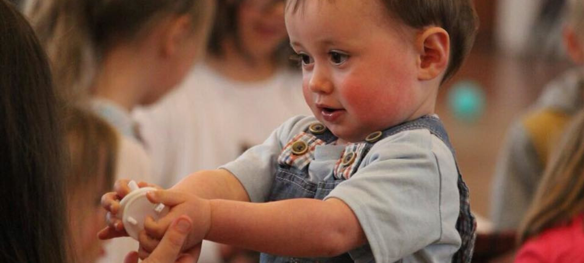 baby interacting with a mum and a toy