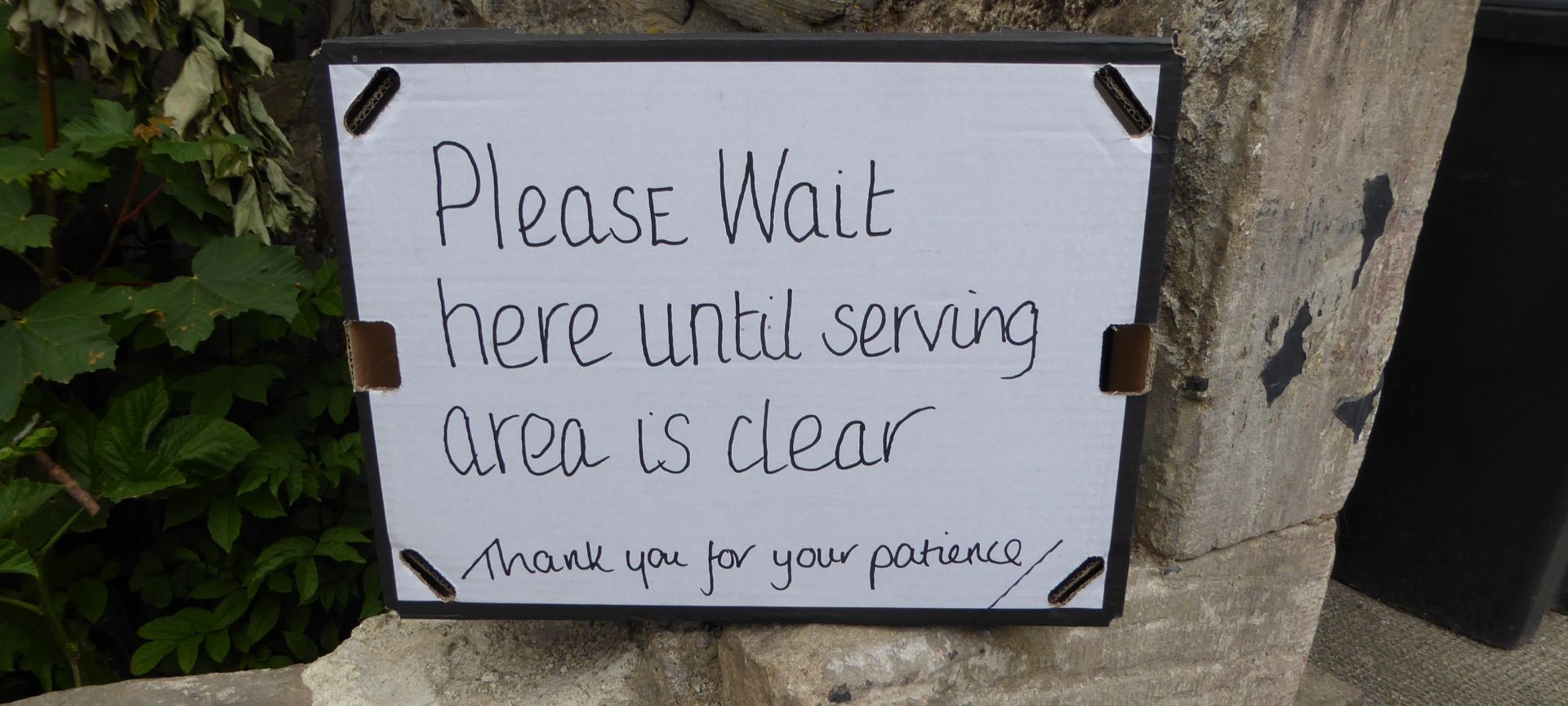 sign saying please wait here until serving area is clear