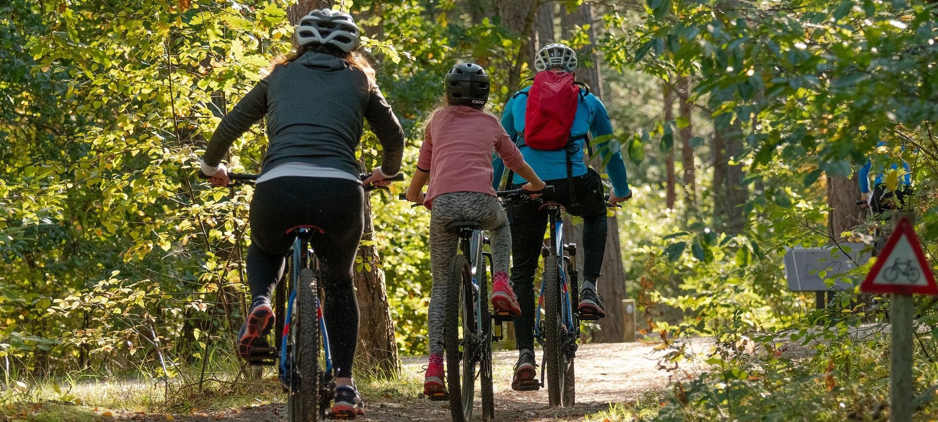 a family cycling through woodland