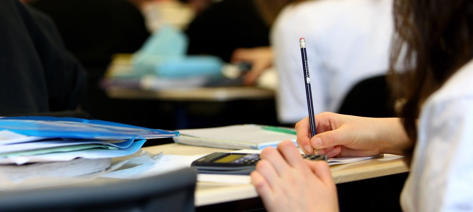 girl writing notes in class