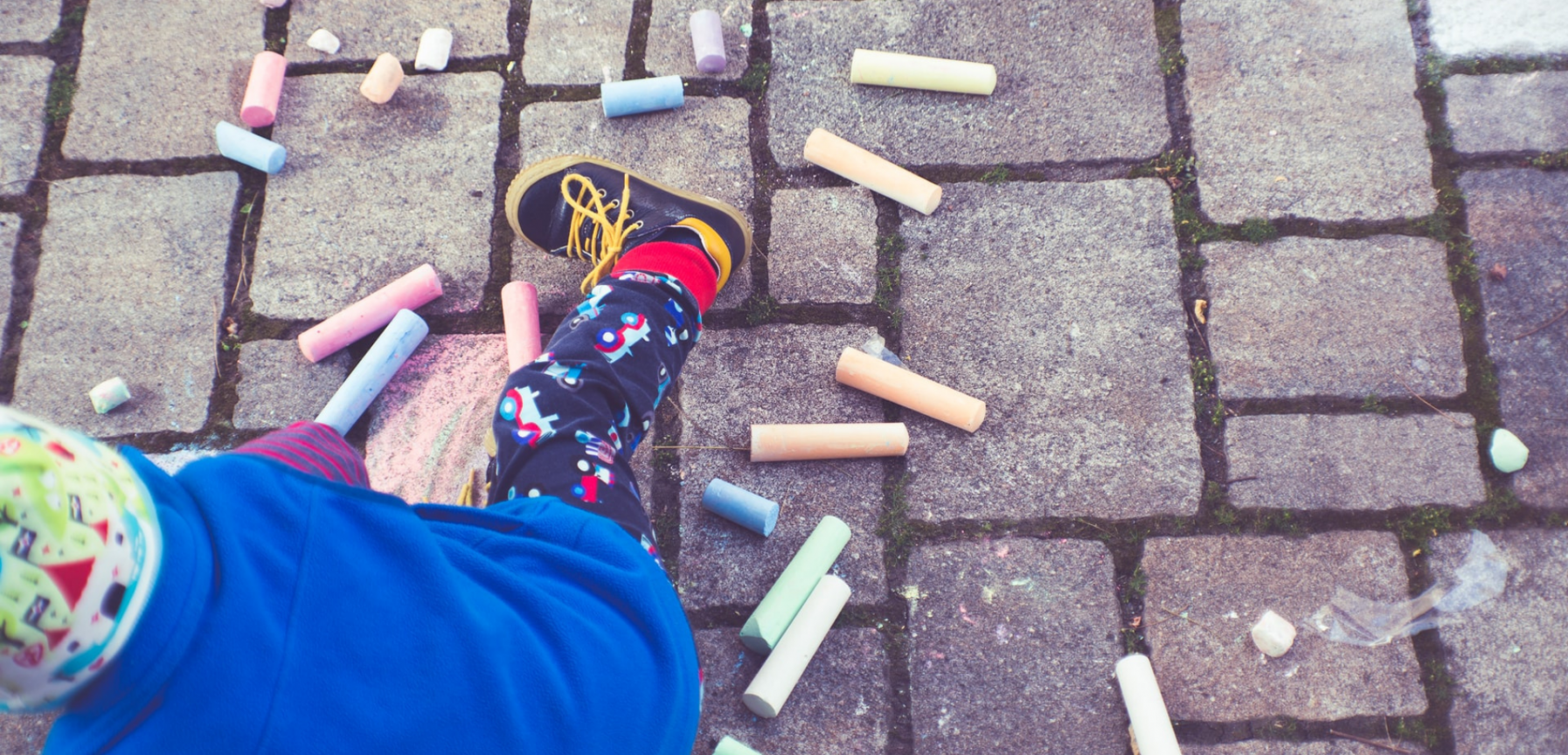 Child playing with chalks in school playground