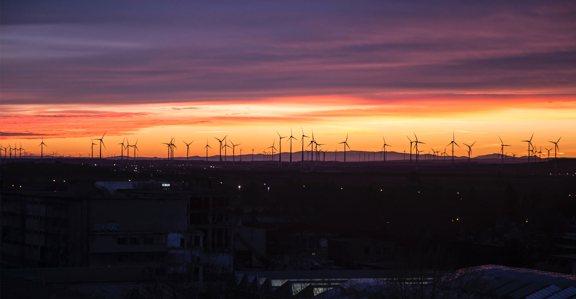 Street lights and wind farm at sunset