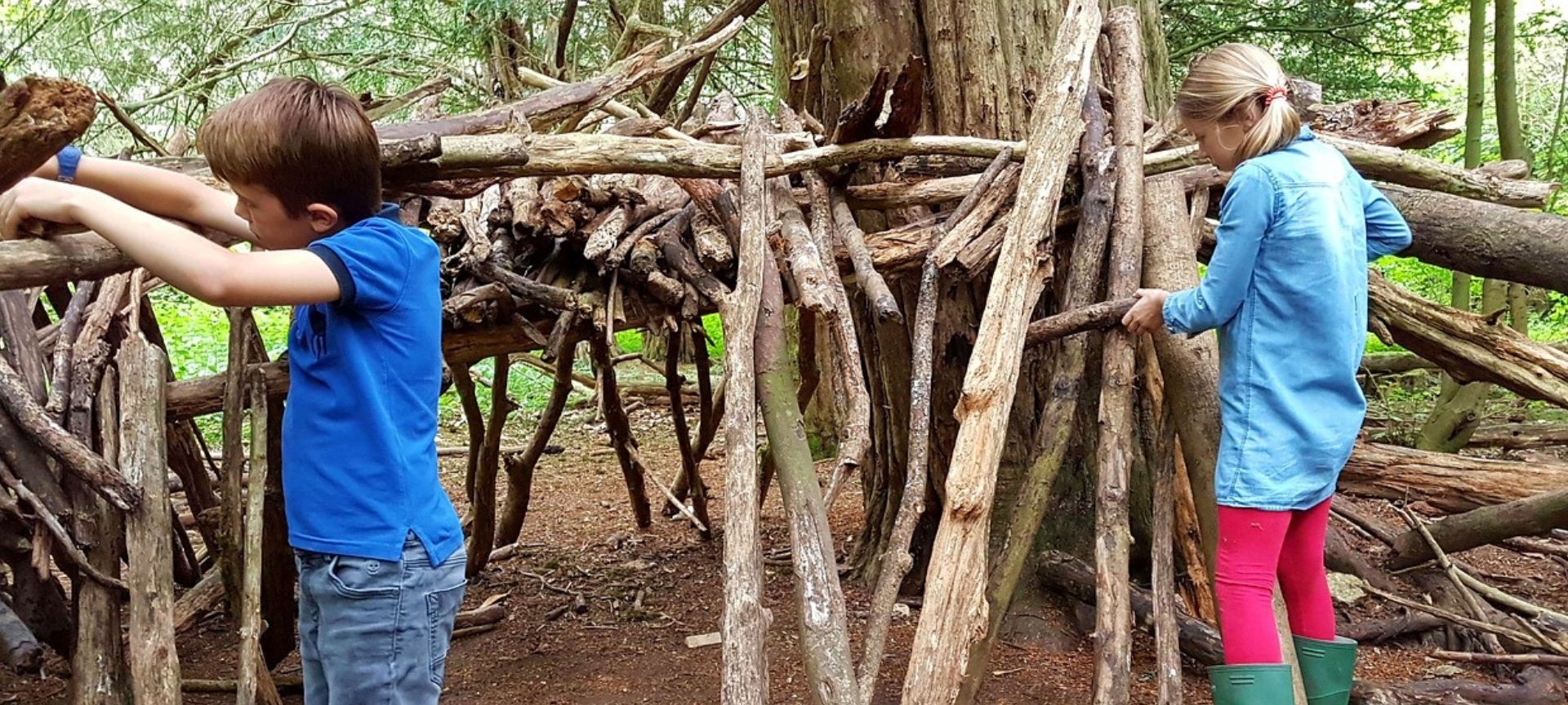 Boy and girl building shelter in woods