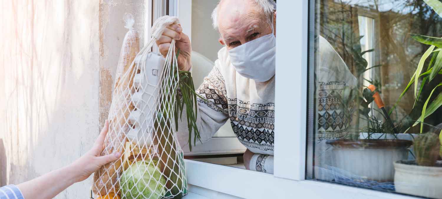 Man receiving food supplies through window