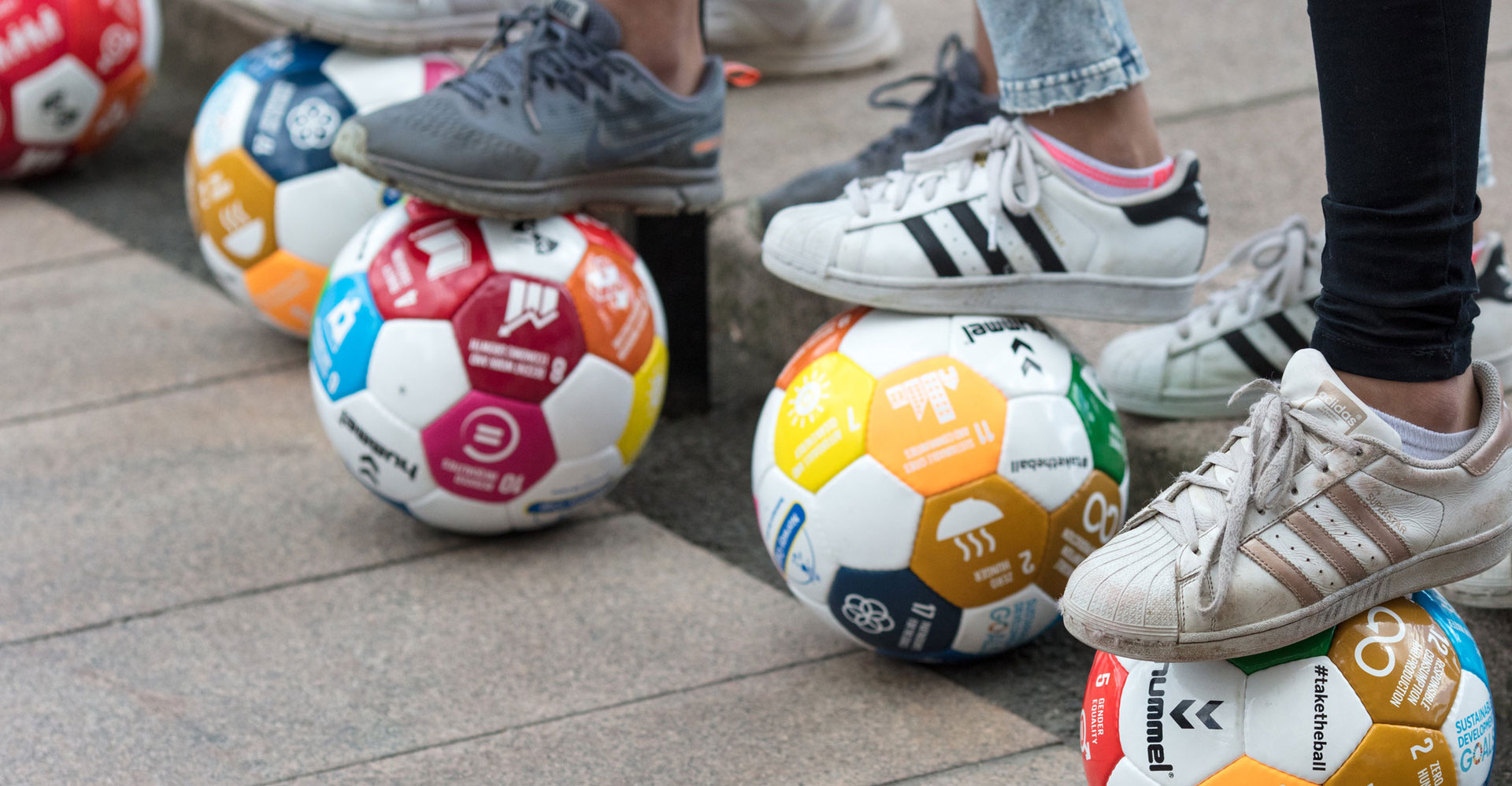 SDG logos on footballs with feet