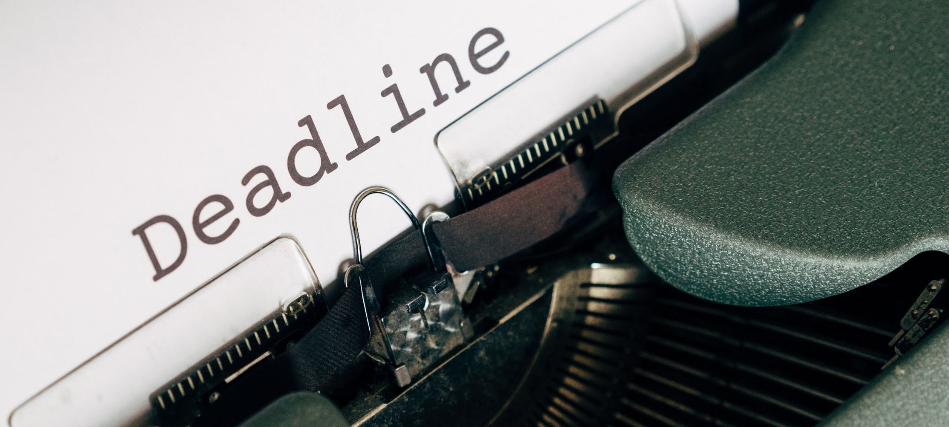 Typewriter with deadline written on paper