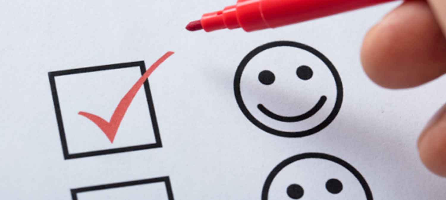 image of someone ticking a happy face icon on a survey
