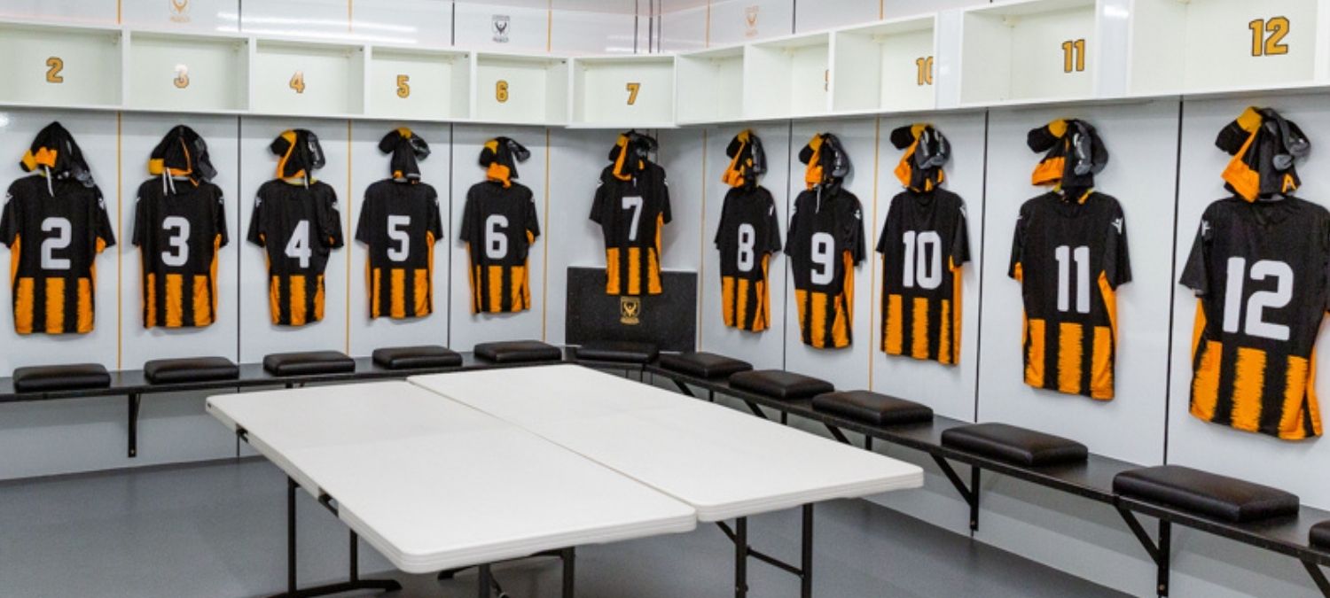 Collection of football kits hanging in a changing room