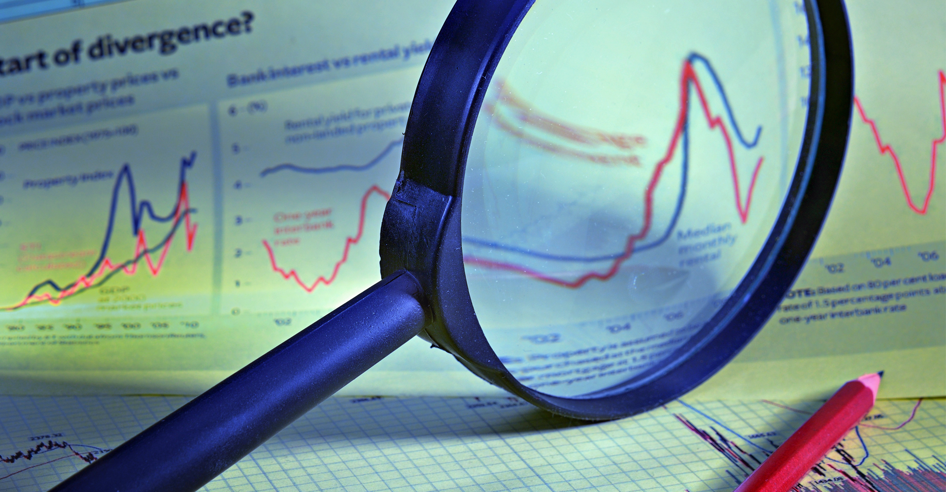 Magnifying glass over financial graphs