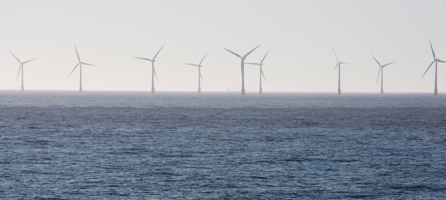 An image of offshore windfarm in a blue ocean