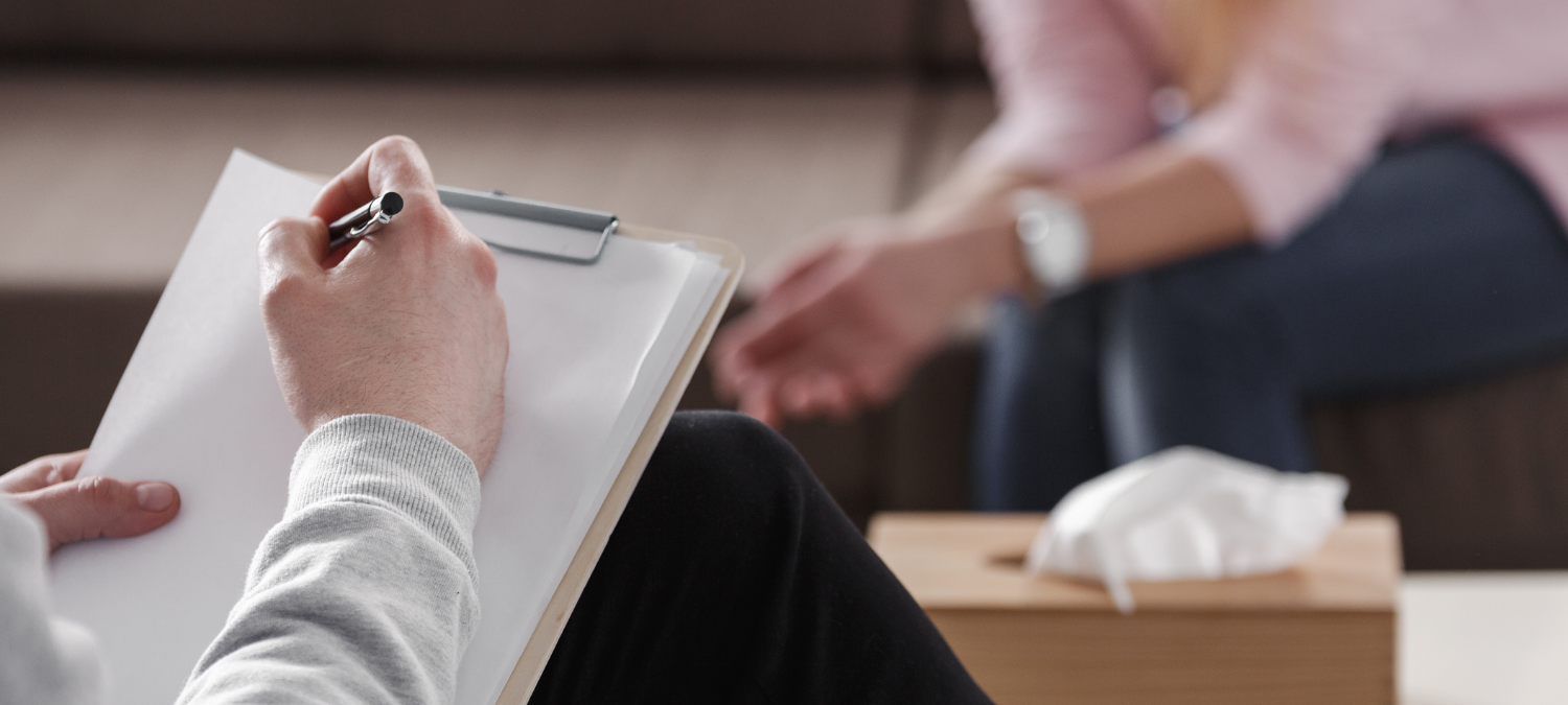 A counsellor making notes whille supporting a young person