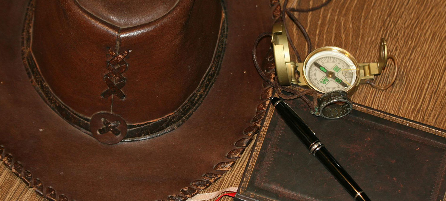 an explorers hat, compass and note book