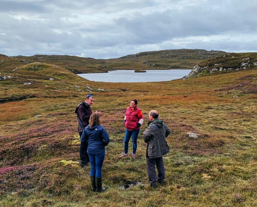 Part of the team having a discussion in front of a body of water