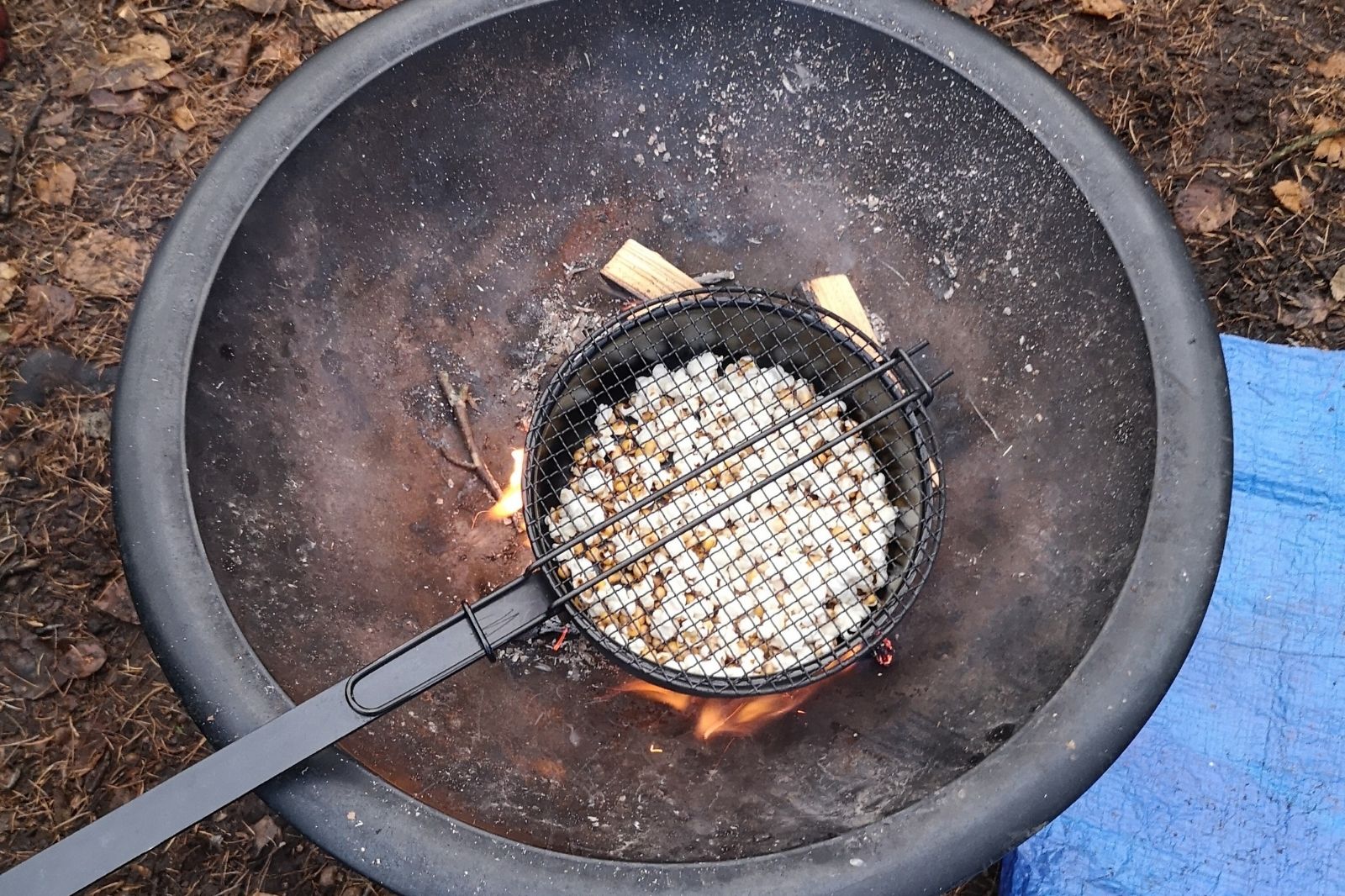 Making popcorn over a fire in the woods