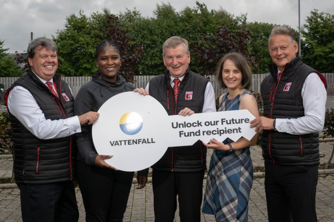 a team holding a large key with the 'Vattenfall logo' and the following text: Unlock our Future Fund recipient.
